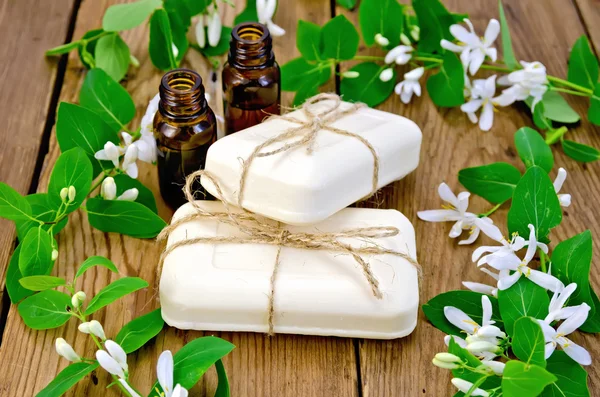 Savon et huile blanc avec des fleurs de chèvrefeuille à bord — Photo