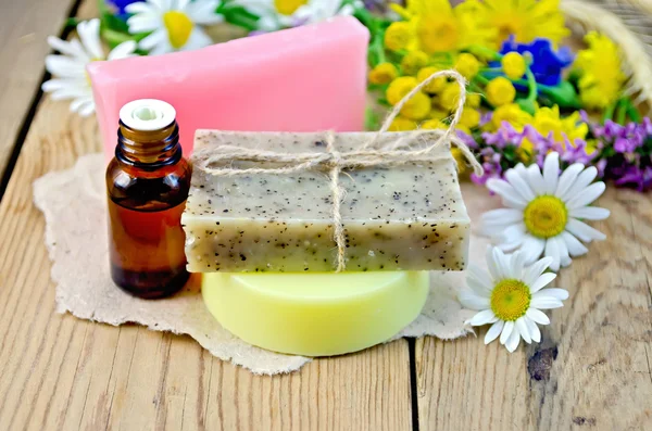 Soap with oil and wildflowers on board — Stock Photo, Image