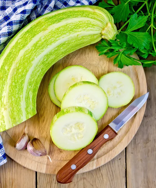 Courgette groen met knoflook en mes aan boord — Stockfoto