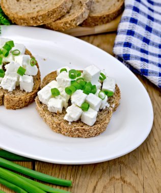 beyaz peynir ve bir plaka üzerinde chives ile ekmek