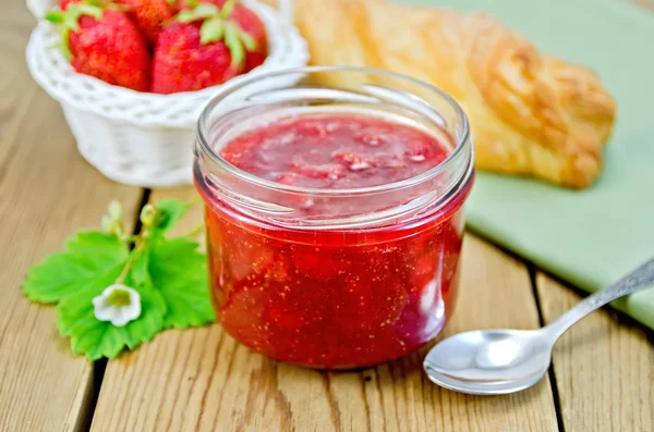 Jam of strawberry with bun and basket on board — Stock Photo, Image