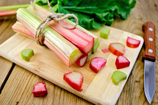 Rhubarb cut on board with knife — Stock Photo, Image