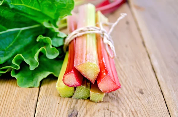 Rhubarb tied with twine with leaf on board — Stock Photo, Image