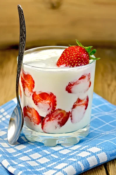 Yogurt thick with strawberries and spoon on board — Stock Photo, Image
