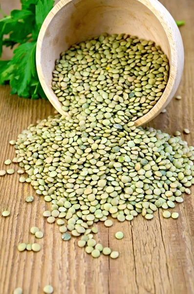 Lentils green in wooden bowl on board — Stock Photo, Image