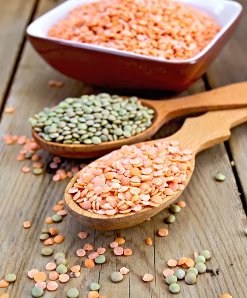 Lentils red and green in spoon with bowl on board — Stock Photo, Image