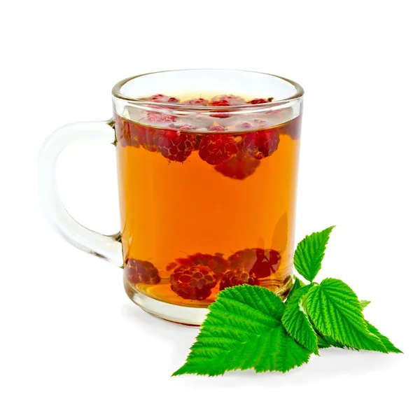 Tea with raspberry and green leaf in glass mug — Stock Photo, Image