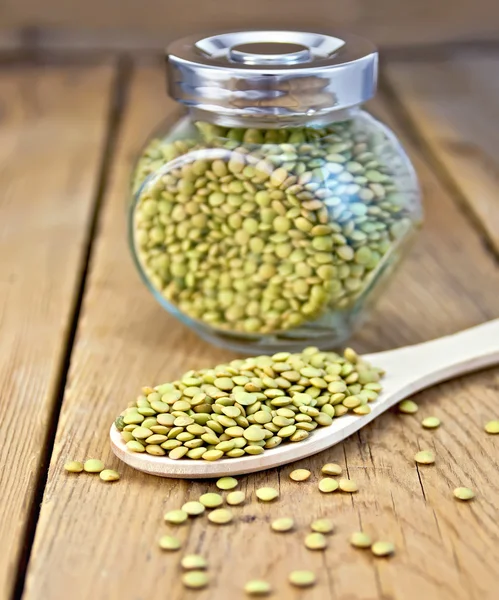 Lentils green in jar and spoon on board — Stock Photo, Image
