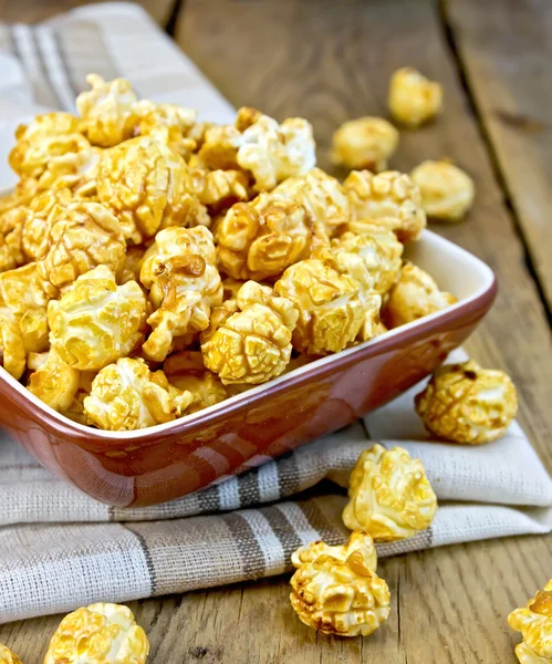 Popcorn karamell ombord i lera skål med servett — Stockfoto