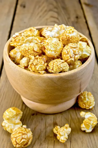 Popcorn karamel in houten kom aan boord — Stockfoto