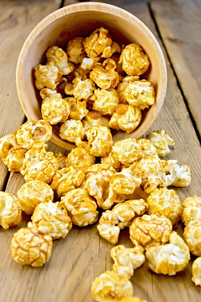 Popcorn caramel on board in wooden bowl — Stock Photo, Image