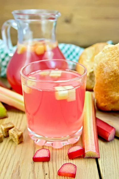 Compote from rhubarb in glass and jug with bread on board — Stock Photo, Image