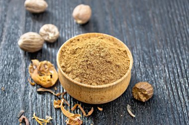 Bir kasede hindistan cevizi, siyah tahta bir arka planda fındık ve kurutulmuş hindistan cevizi arillus