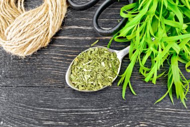 Kaşıkta kurutulmuş tarhun, taze estragon, yukarıdan siyah tahta arka planda sicim ve makas karışımı.