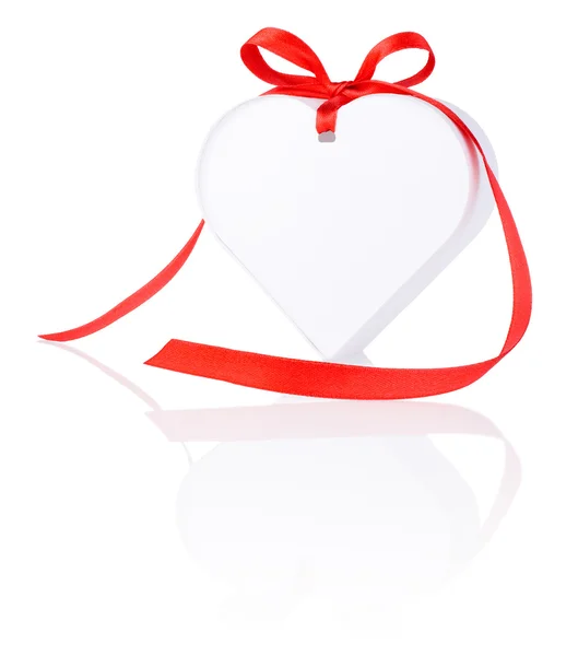 White gift in the form of heart with a bow of red ribbon Isolate — Stock Photo, Image