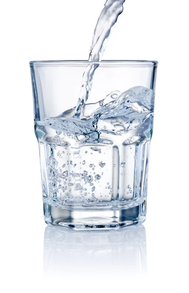 Agua vertiendo en vasos aislados sobre un fondo blanco — Foto de Stock