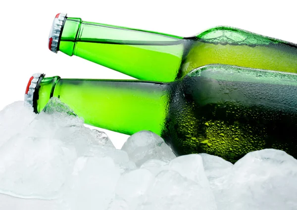 Крупный план Две зеленые бутылки пива с конденсатом прохладно во льду — стоковое фото
