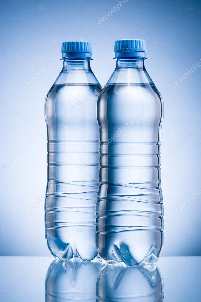 Two plastic bottle of drinking water isolated on blue background