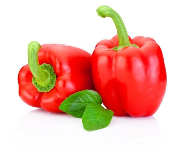 Due peperoni rossi dolci con foglie verdi isolate su dorso bianco — Foto Stock