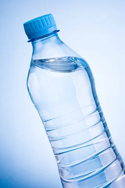 Szczegół plastikowe butelki wody pitnej ukośnie na niebieski ba — Zdjęcie stockowe