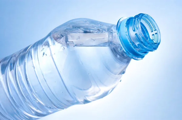 Aprire una bottiglia d'acqua su sfondo blu — Foto Stock