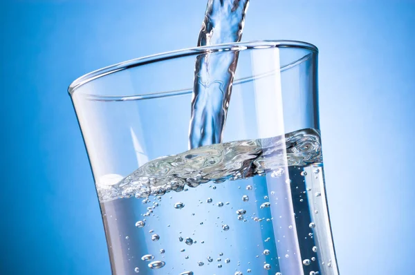 Wasser Ergießt Sich Glas Auf Blauem Hintergrund — Stockfoto