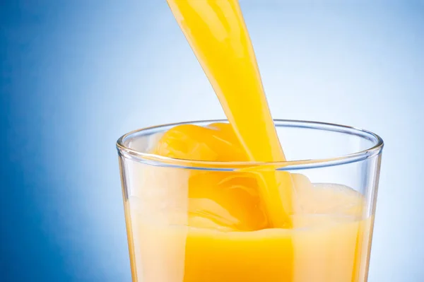 Orange Juice Pouring Glass Blue Background — Stock Photo, Image