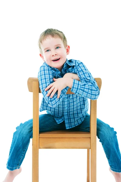 Cheerful boy sitting on a chair — Stock Photo, Image