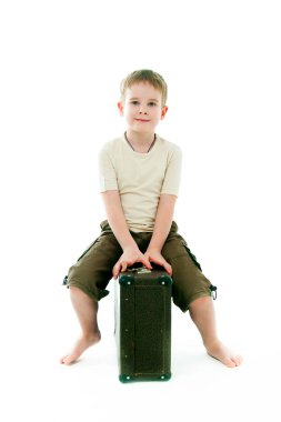 bavula çocuk oturur