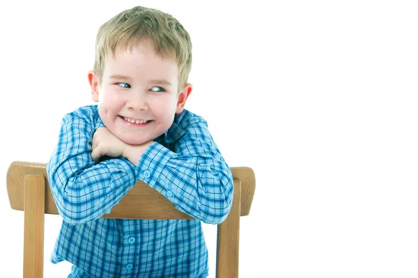 Garçon joyeux assis sur une chaise — Photo