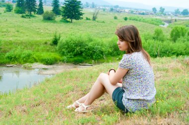 Kız kayanın üzerinde oturur