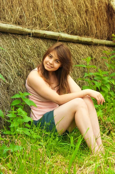 Young beautiful woman is standing near a straw — Stock Photo, Image