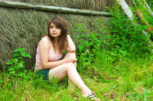 Jonge mooie vrouw is permanent in de buurt van een rietje — Stockfoto