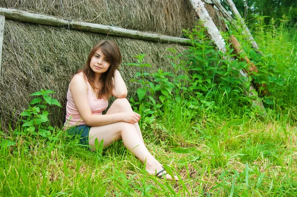 Jeune belle femme se tient près d'une paille — Photo