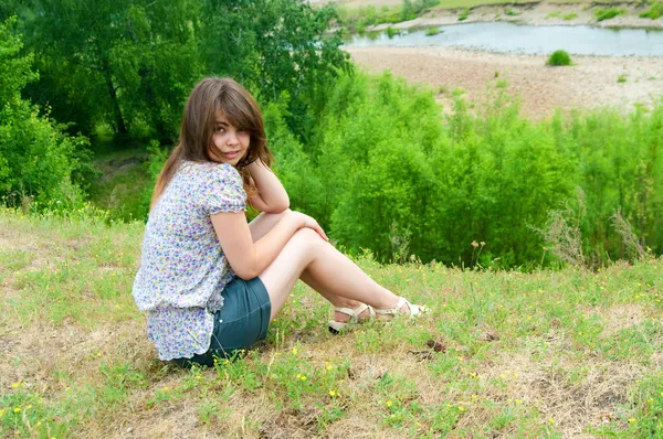 A menina senta-se na rocha — Fotografia de Stock