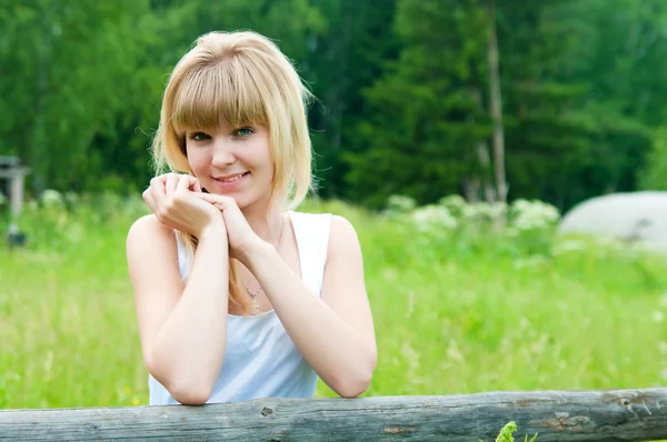 The girl stands near a fence — Stock Photo, Image