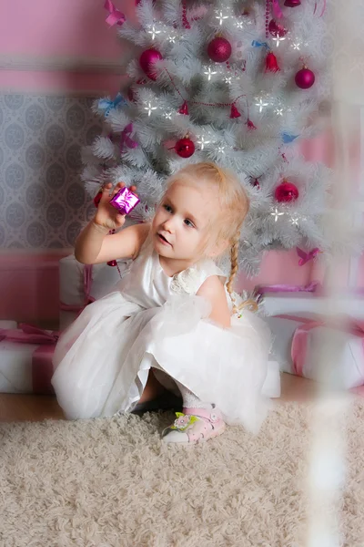 Het meisje op de spar-kerstboom met geschenken — Stockfoto