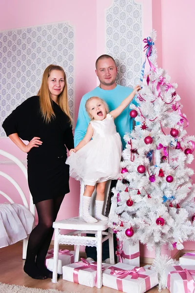 A menina com pais no abeto de Natal com presentes — Fotografia de Stock