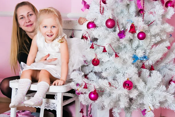 Het meisje met ouders bij de fir-kerstboom met geschenken — Stockfoto