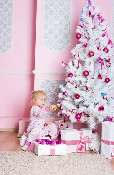 Het meisje op de spar-kerstboom met geschenken — Stockfoto