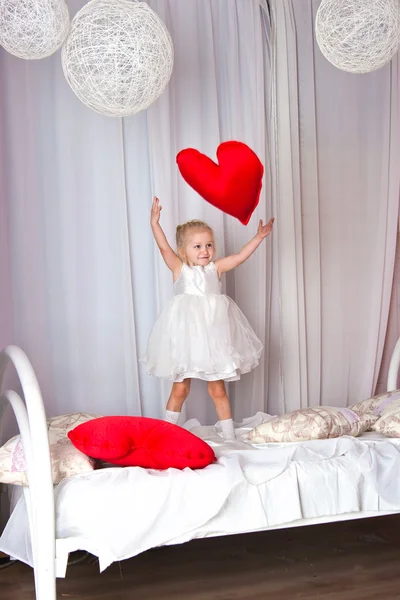 The girl jumps on a big bed — Stock Photo, Image