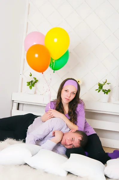 Жінка в фіолетовому одязі з чоловіком лежить на підлозі — стокове фото