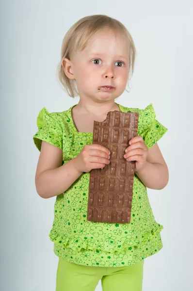 Chica joven comiendo barra de chocolate — Foto de Stock
