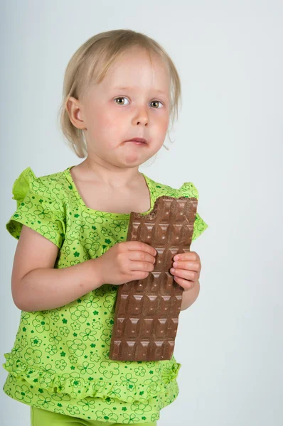 Menina comendo bar de chocolate — Fotografia de Stock
