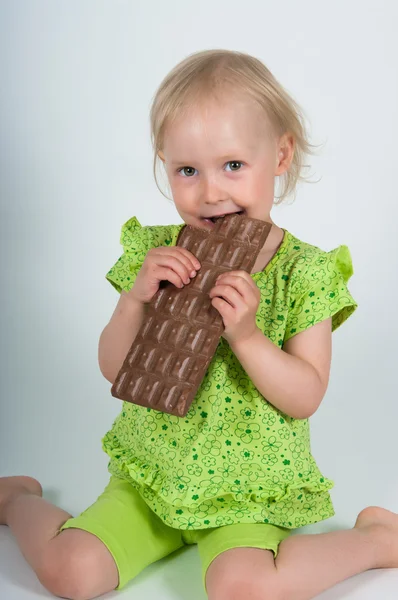 Chica joven comiendo barra de chocolate — Foto de Stock