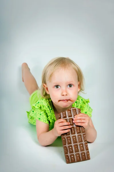 Ung flicka äter bar choklad — Stockfoto