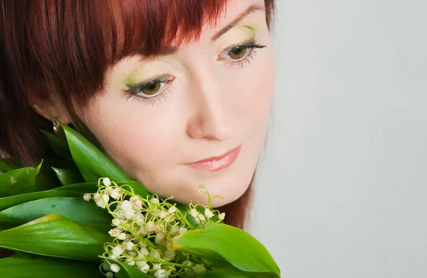 The girl with a bouquet of lilies of the valley — Stock Photo, Image