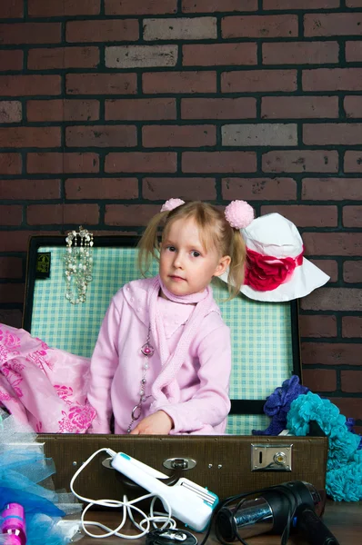 Little warmly dressed girl packs a suitcase with summer things — Stock Photo, Image