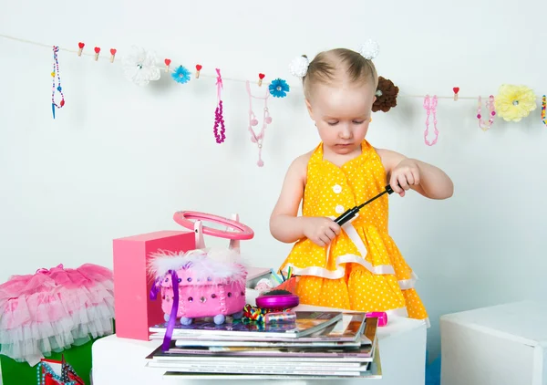 Menina elegante brincando com cosméticos e jóias — Fotografia de Stock