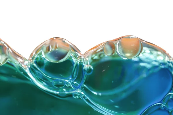 Bolhas azuis em água clara contra branco — Fotografia de Stock